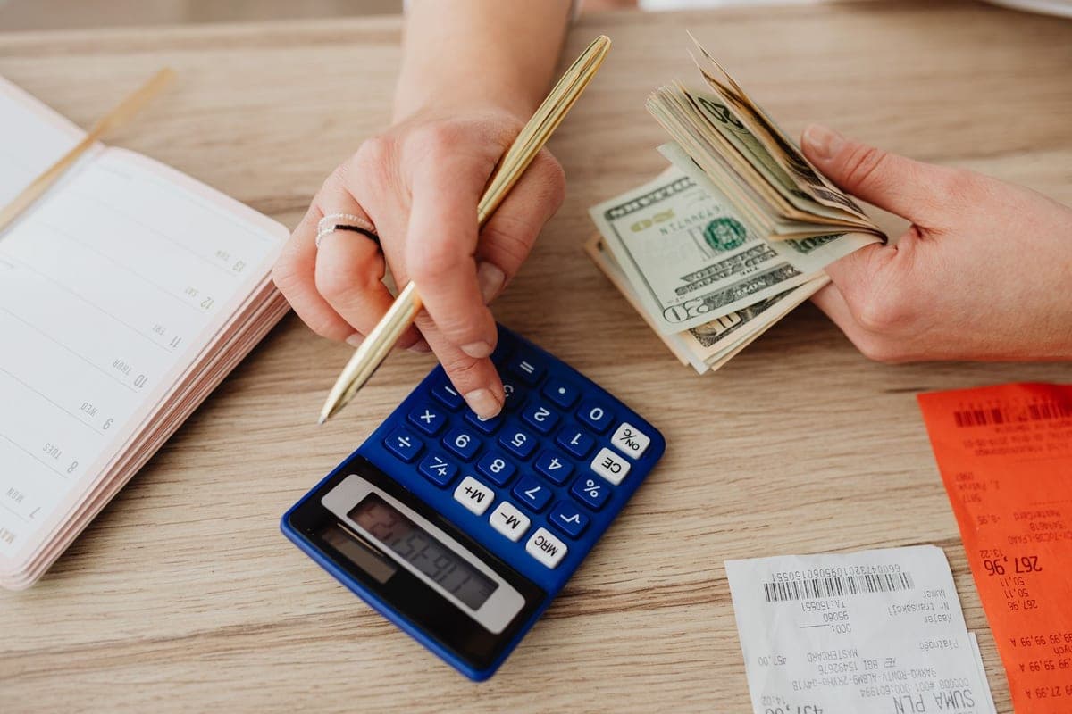 A notebook and calculator on a desk, used for working out household costs